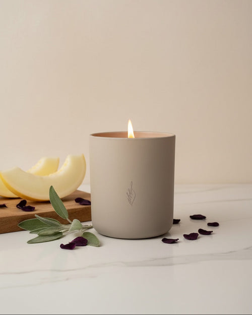Candle in a beige container with a minimal background